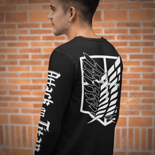 Man wearing black long sleeve shirt featuring a Attack on Titan shield on back and logo down sleeve